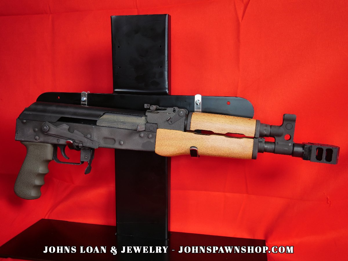The Century Arms VSKA Draco AK pistol, a semi-automatic firearm available at John's Loan & Jewelry, is presented in a full profile view, showing its compact design and characteristic AK features.