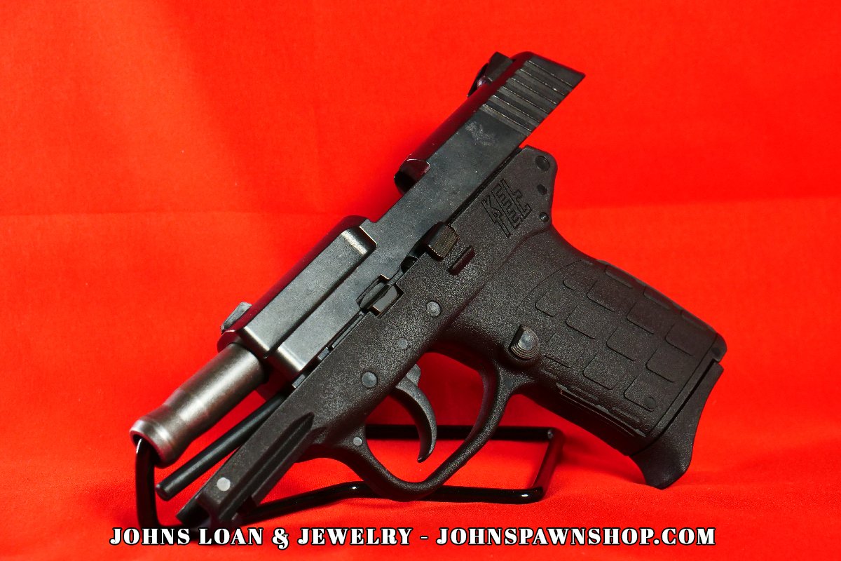 Angled perspective of a KelTec PF-9 semi-auto pistol, with a stainless barrel, showcased by John's Loan & Jewelry, emphasizing its compact polymer frame for concealment.