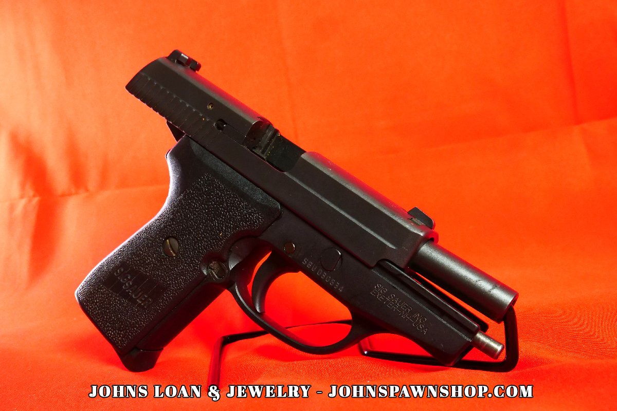 Angled view of a Sig Sauer P239 semi auto pistol, with the slide slightly retracted, showcasing the firearm's inner mechanisms at John's Loan & Jewelry.