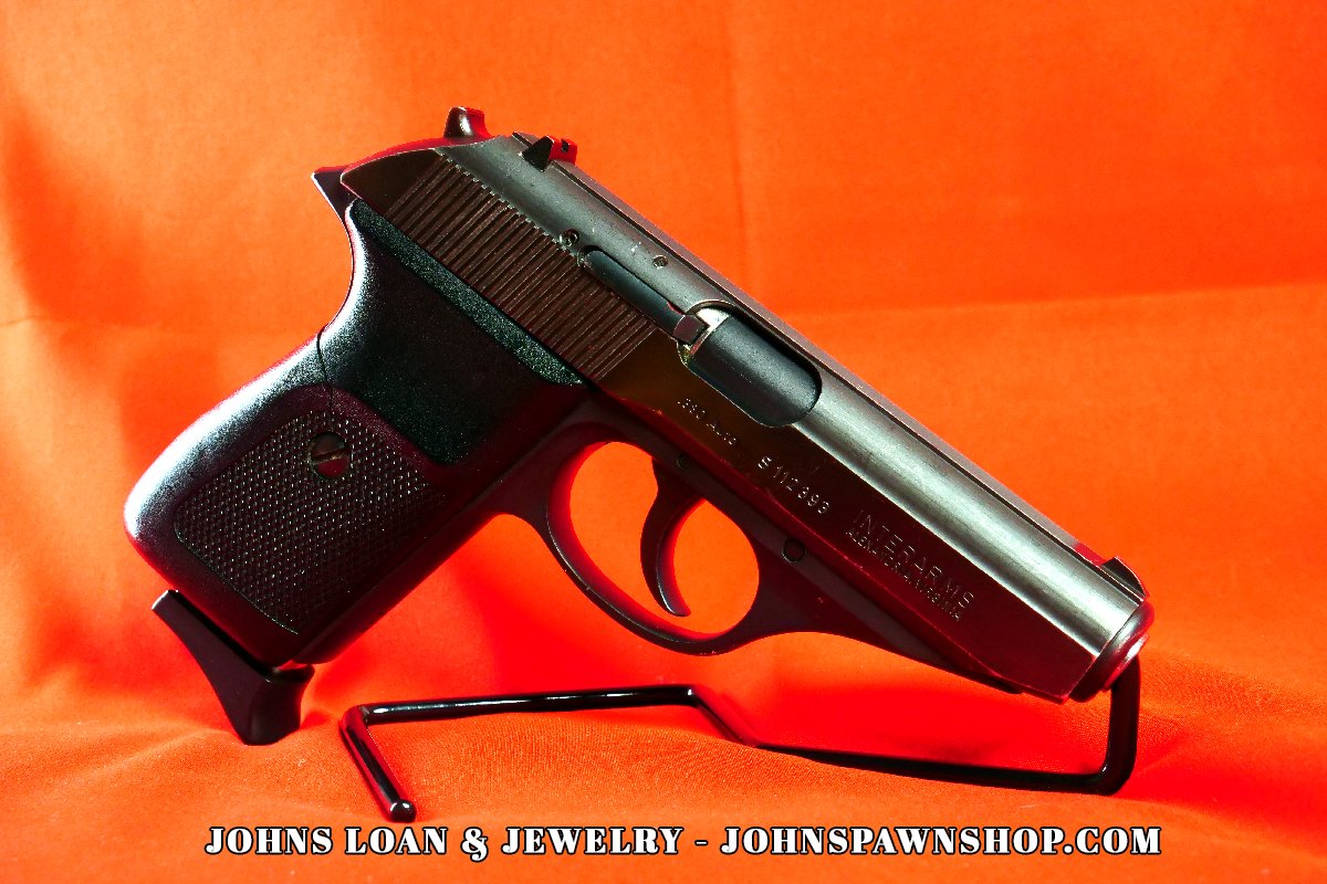 Sig Sauer P230 pistol chambered in .380 ACP, showcased on a black stand against an orange backdrop, offered by John's Loan & Jewelry as a perfect CCW nightstand gun.