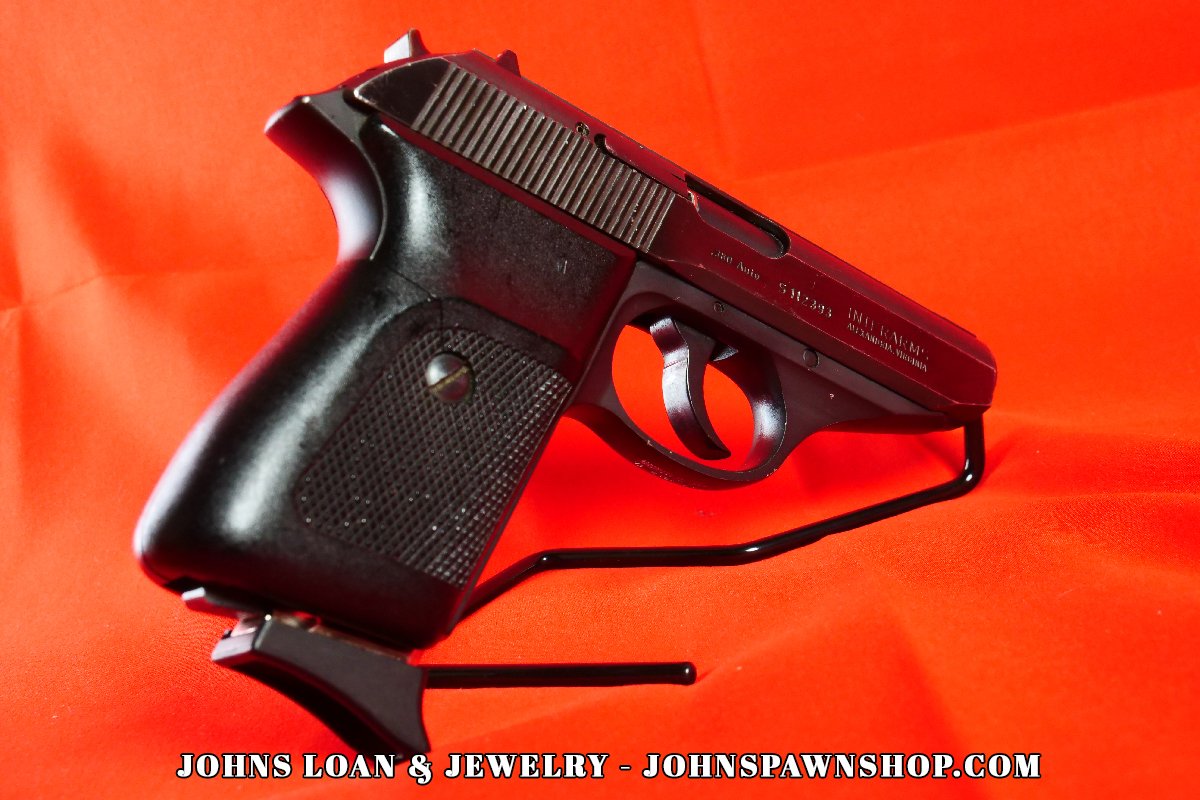 Perspective shot of a Sig Sauer P230 .380 ACP pistol on display, highlighting the black grip texture, offered by John's Loan & Jewelry as a perfect CCW nightstand gun.