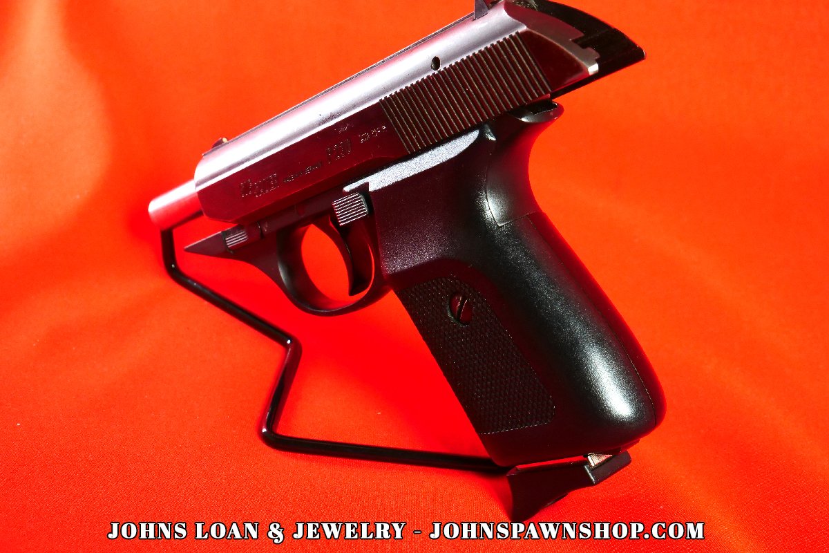 Close-up showing the grip and slide of a Sig Sauer P230 .380 ACP pistol, offered by John's Loan & Jewelry, emphasizing its profile as a reliable firearm.