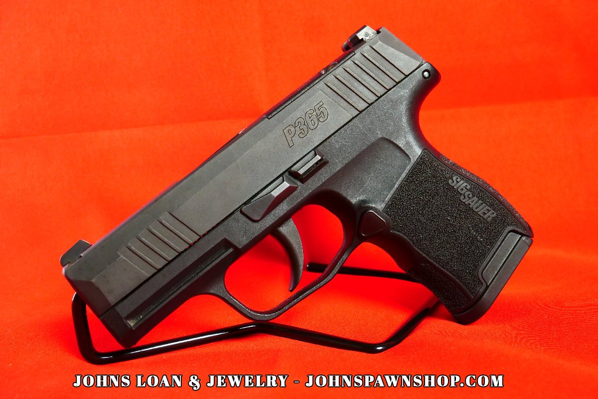 A Sig Sauer P365 9mm semi-auto pistol with textured polymer grip, slide markings, and night sights; available from John's Loan & Jewelry.