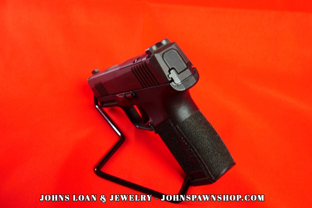 The Sig Sauer P365 semi-auto pistol, angled view showing the grip and XRAY3 night sights, presented by John's Loan & Jewelry.