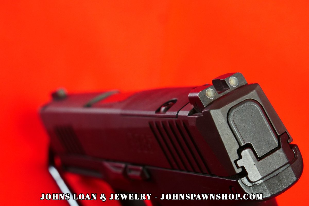 Detailed rear view of the Sig Sauer P365 slide, exhibiting the night sights and slide serrations, available at John's Loan & Jewelry pawn shop.