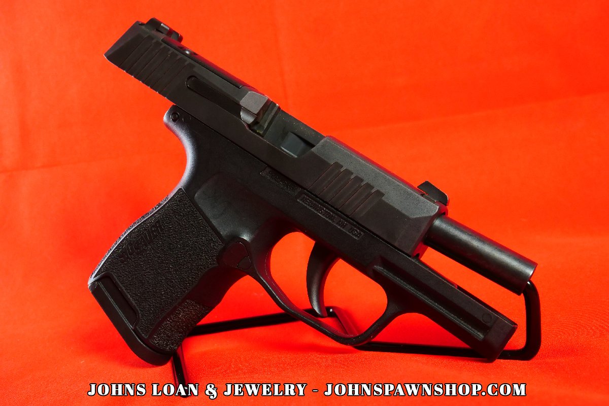 Side view of a Sig Sauer P365 semi-auto pistol with visible slide serrations, night sights, and frame details, offered by John's Loan & Jewelry.