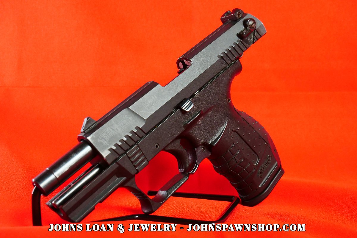 Walther P22 pistol with the slide partially retracted, revealing the internal components; sold by John's Loan & Jewelry as a lightweight plinker and concealed carry training option.