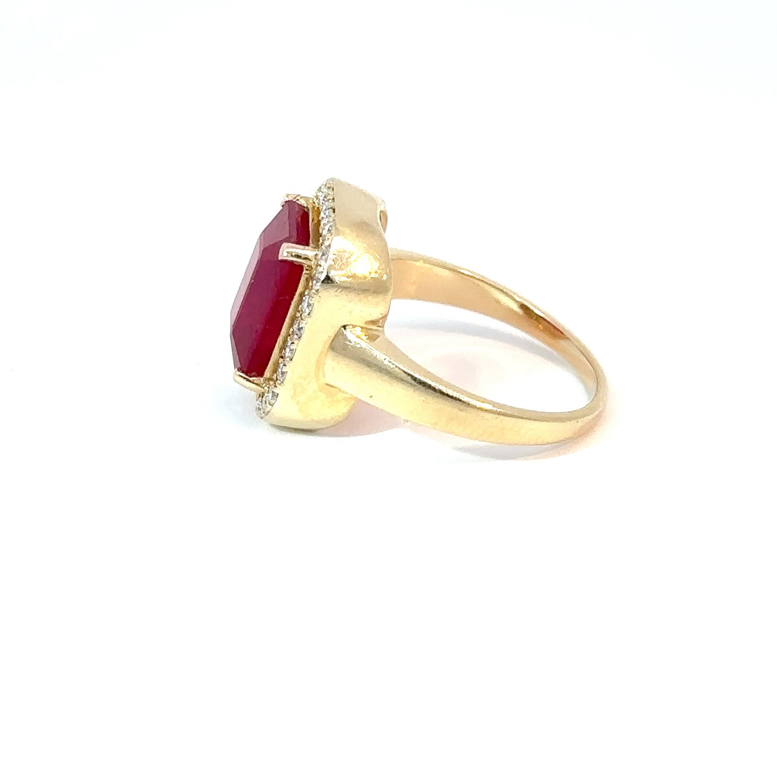 Close-up, angled side-view of John's Loan & Jewelry 14k yellow gold ruby and diamond ring, focusing on the gemstone's facets and accent stone details.