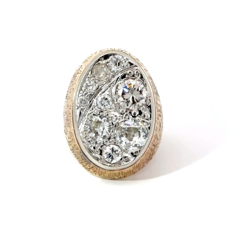 Close-up of a John's Loan & Jewelry men's pinky ring featuring a 14k yellow gold band with a 'Starry Night' diamond cluster setting on a white table.