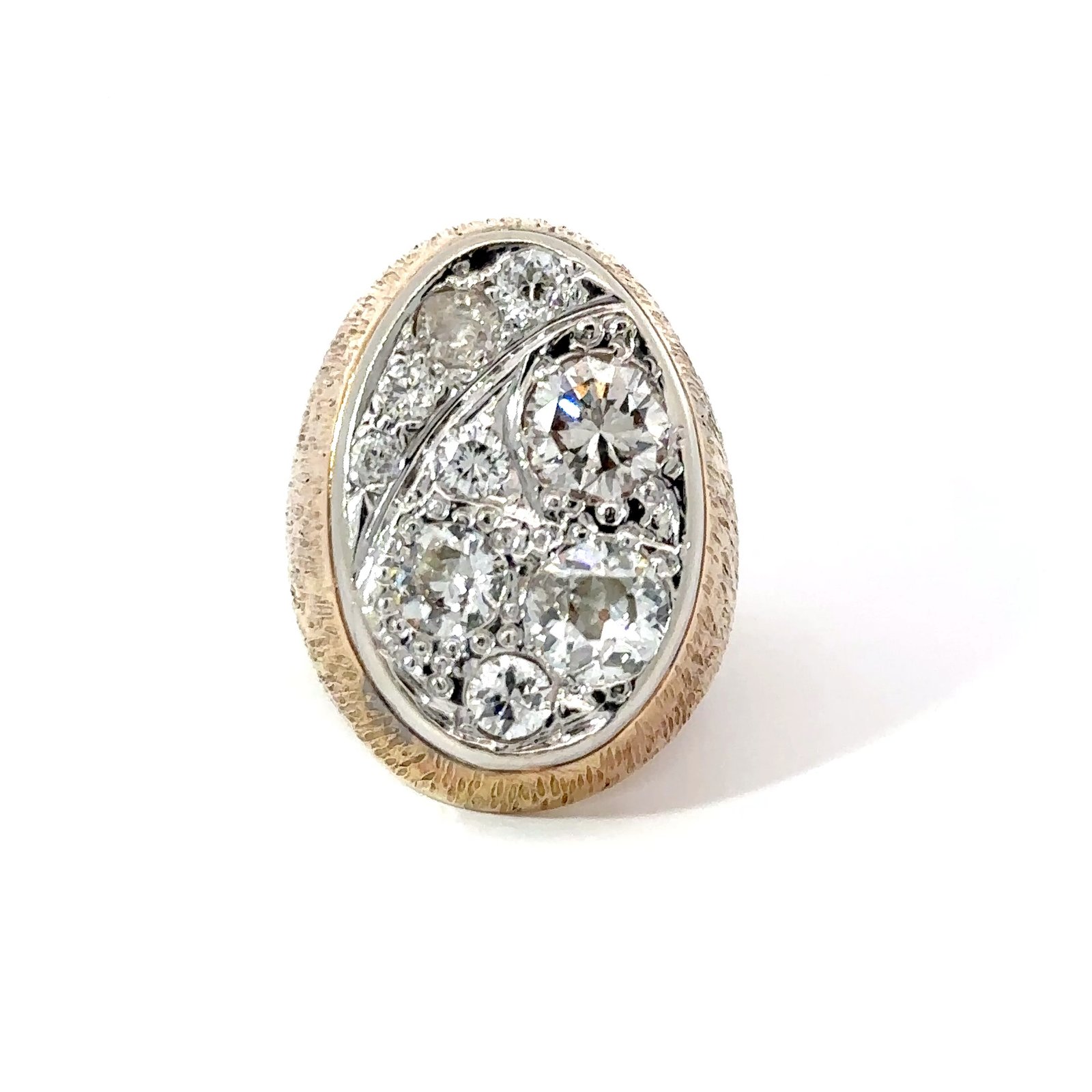 Close-up of a John's Loan & Jewelry men's pinky ring featuring a 14k yellow gold band with a 'Starry Night' diamond cluster setting on a white table.