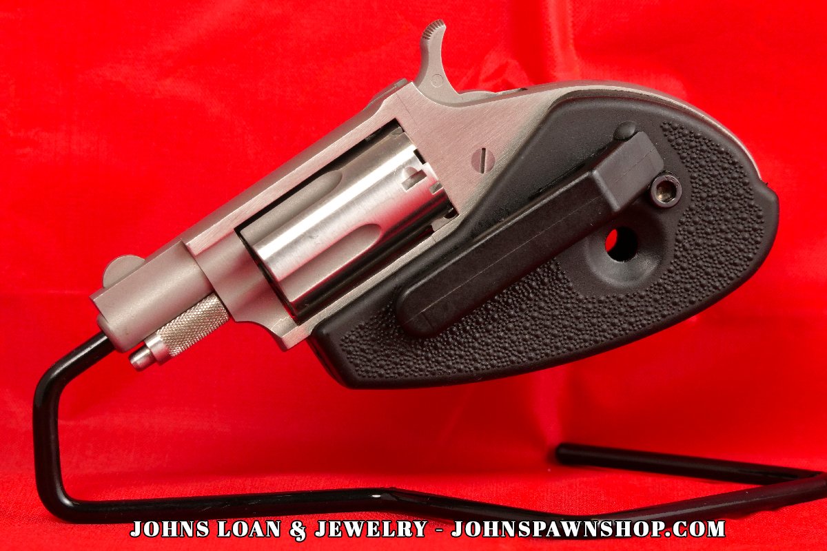 The American-made North American Arms .22 Magnum revolver from John's Loan & Jewelry, presented with its textured black holster grip and stainless steel construction in near perfect shape.