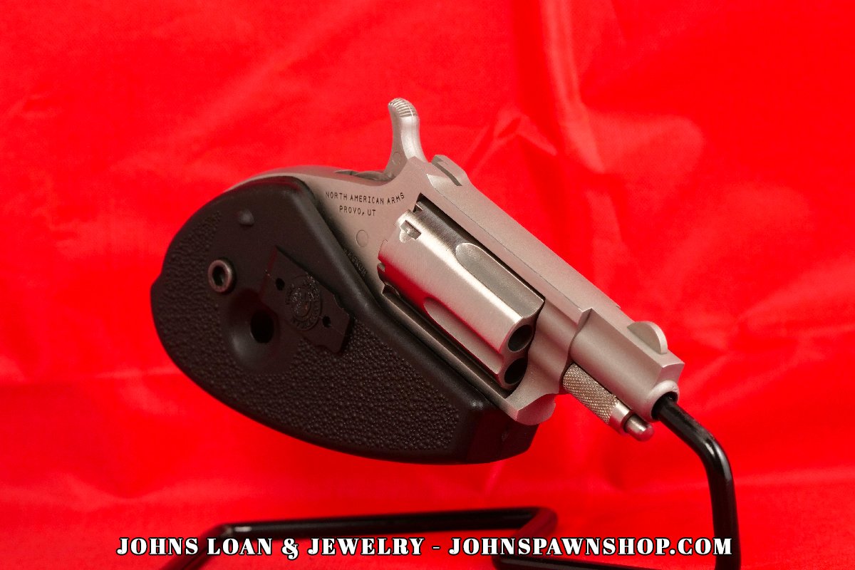 The North American Arms .22 Magnum revolver from John's Loan & Jewelry, highlighting the American-made firearm's stainless steel finish, 5-shot capacity, and textured holster grip in near perfect shape.