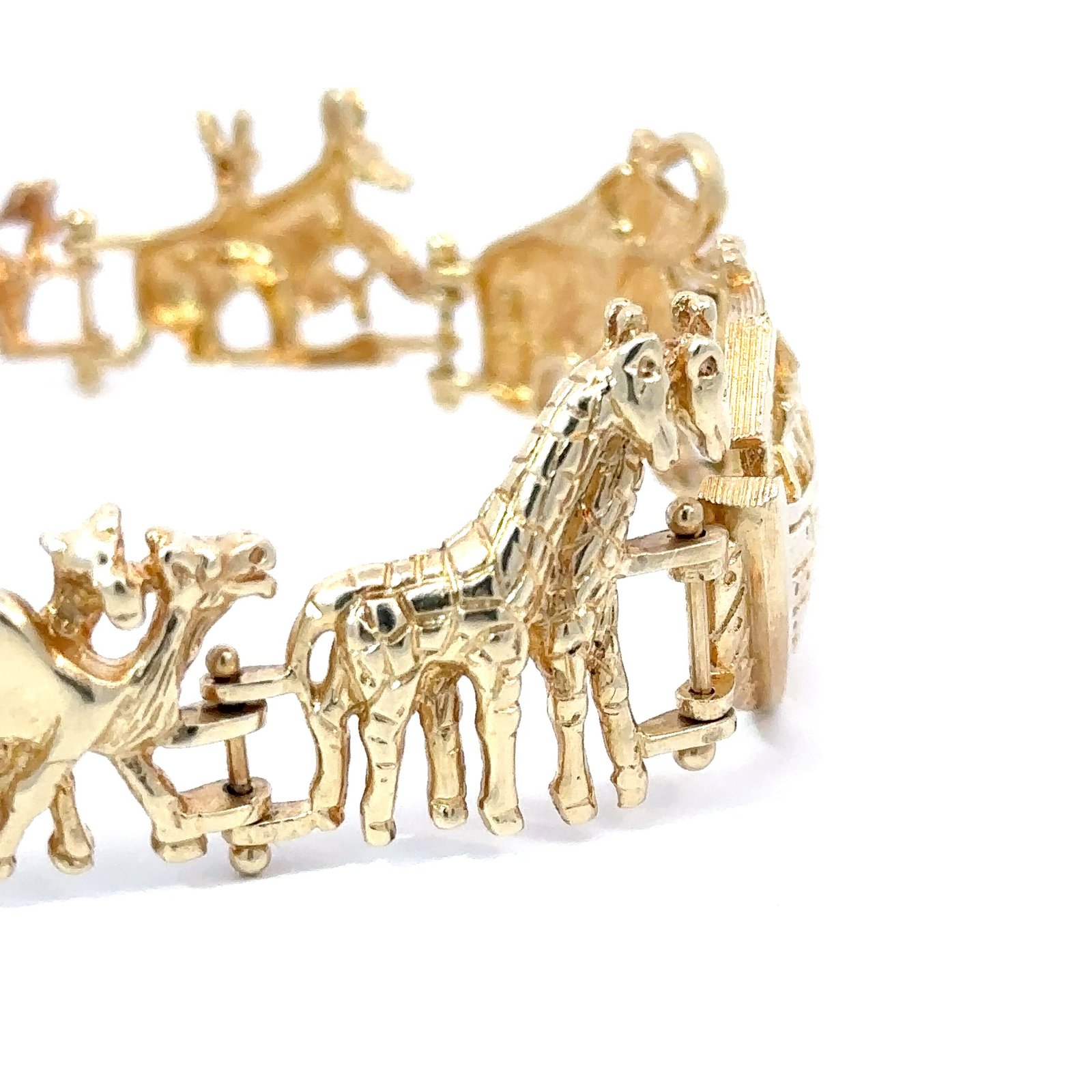 Side-profile view of the 14k gold Noah's Ark bracelet from John's Loan & Jewelry, highlighting the animal motifs. This jewelry features giraffe and camel charms on a white surface.