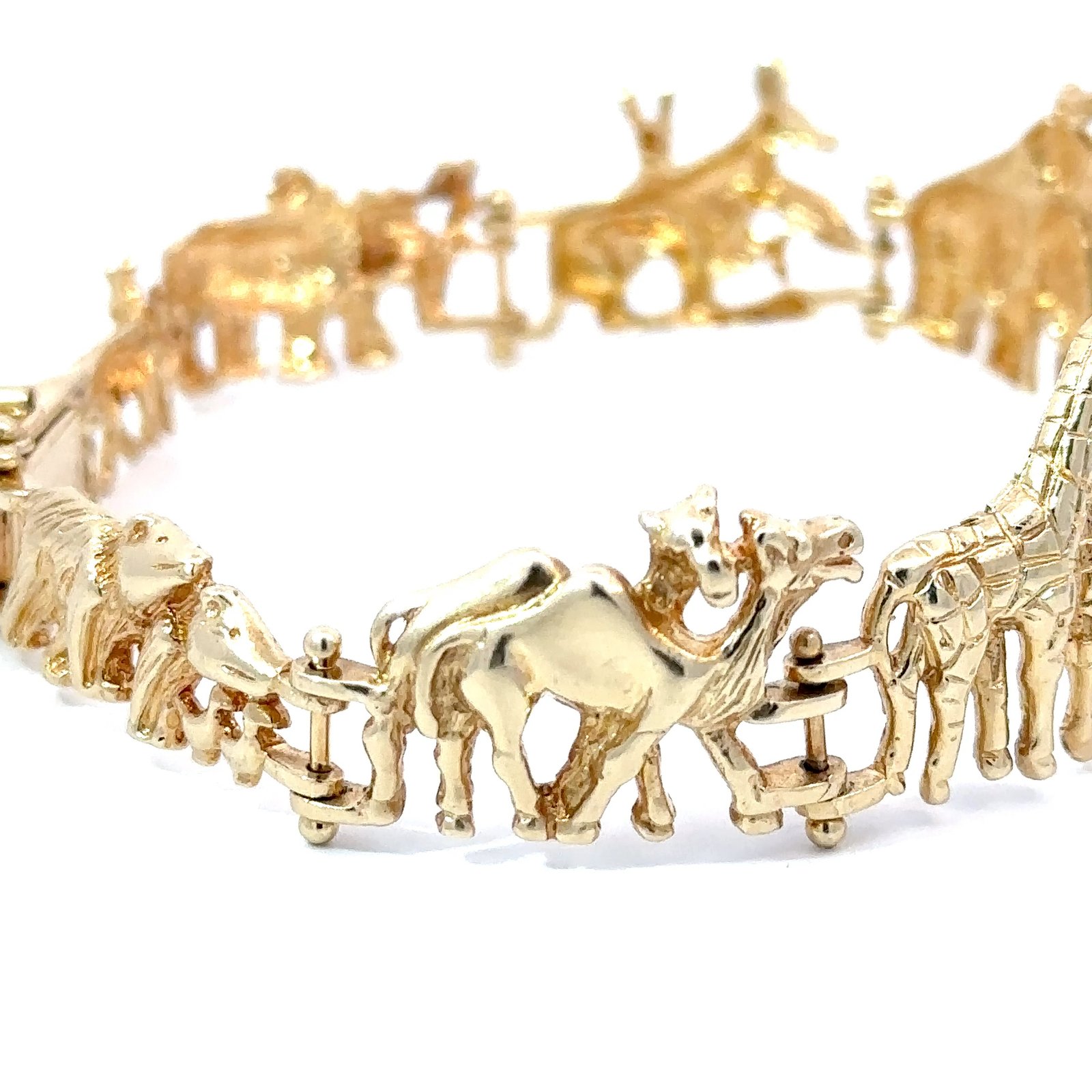 Detailed image of John's Loan & Jewelry 14k yellow gold bracelet, showing intricate animal motifs like camels and a lion. This fine jewelry, featuring Noah's Ark theme, rests on a white surface.