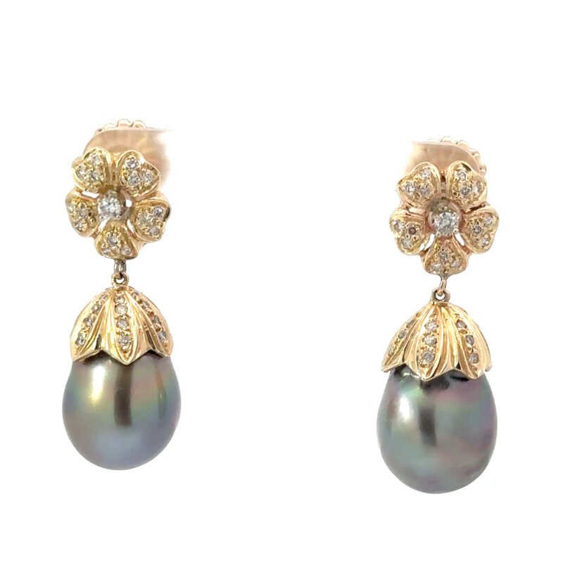 Close-up image of John's Loan & Jewelry 14k gold dangle earrings, each featuring a floral diamond cluster above a textured gold cap and a lustrous black pearl drop.