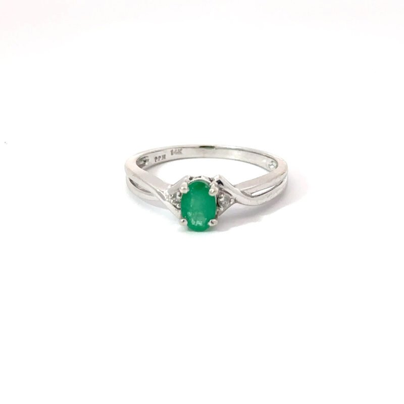 Oval-cut 0.3ct emerald solitaire ring in polished 14k white gold setting from John's Loan & Jewelry; detail shows split shank and subtle diamond accents.