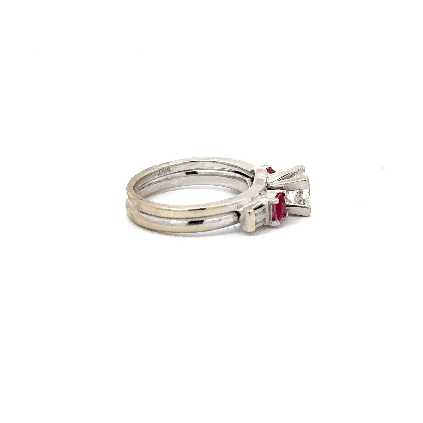 Angled side shot of a 14kt white gold engagement ring from John's Loan & Jewelry, highlighting the princess cut diamond, ruby accents, and the ring's overall jewelry design.